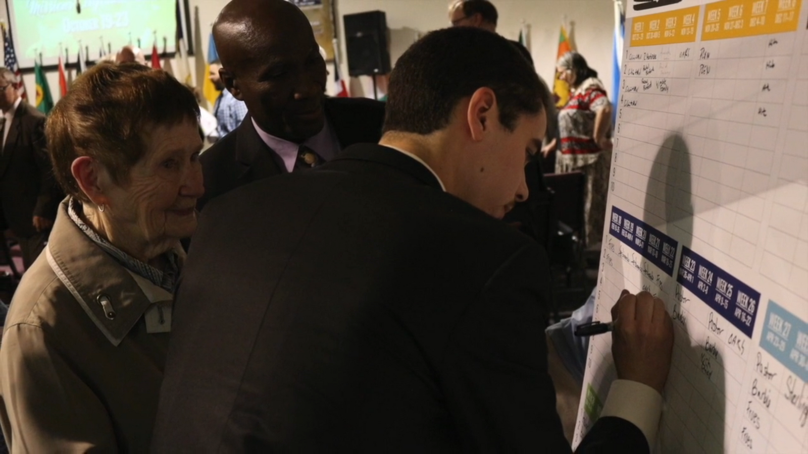 People writing their names on the sign-up chart